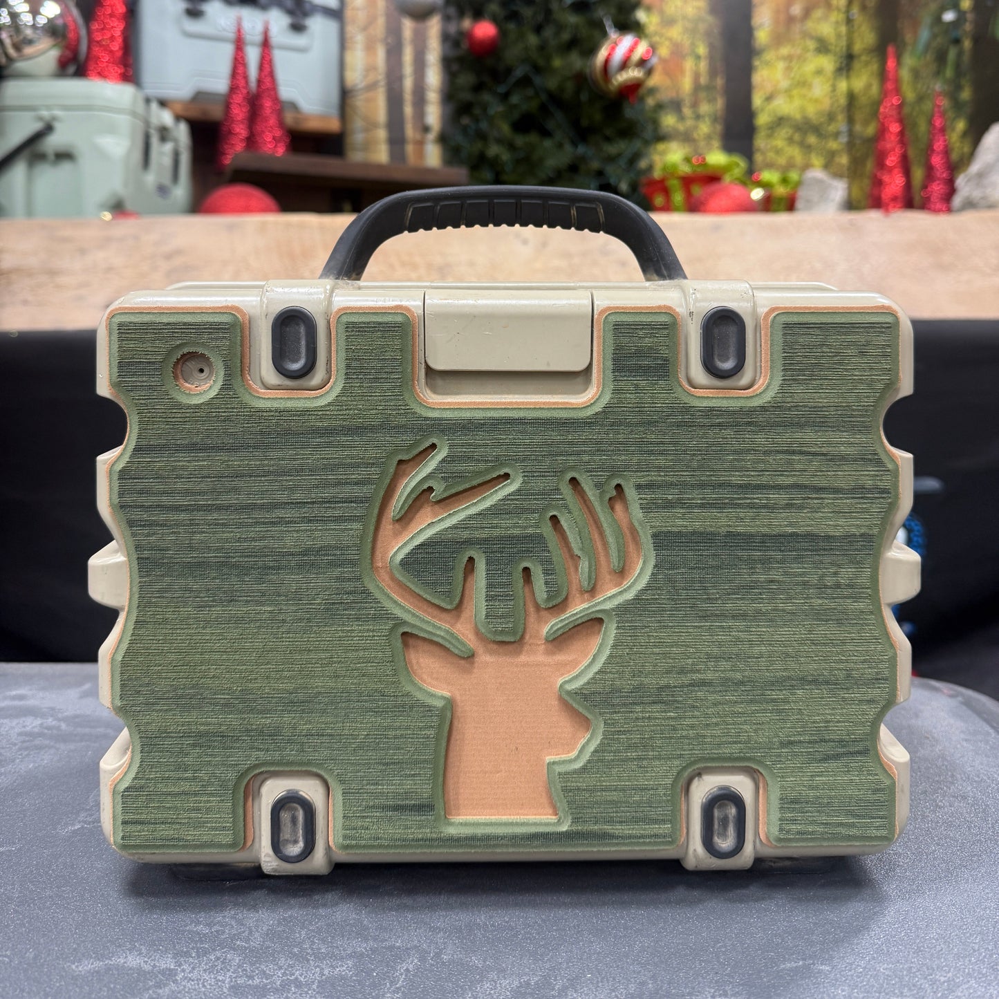 Green phone case with a deer logo on a blurred indoor background